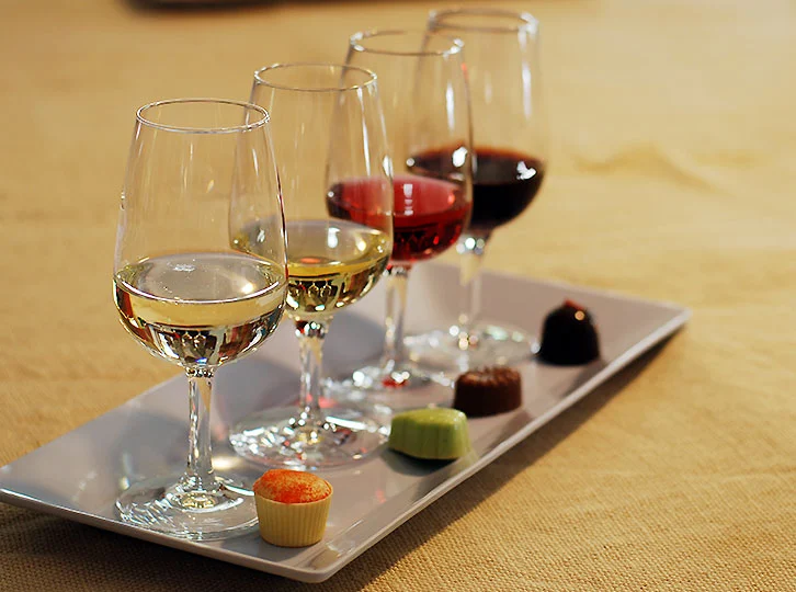 Glasses of wine and a single chocolate next to glasses