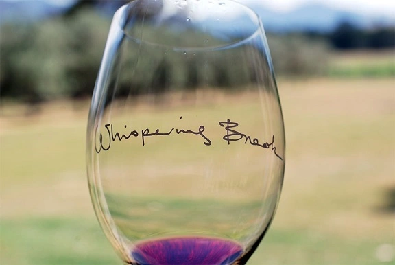 close up of wine glass with Whispering Brook logo