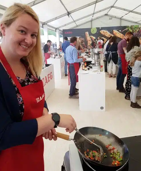 Roma wearing red apron at Taste of London cooking demonstration