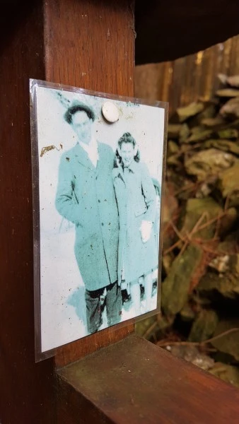 Photograph pinned to gravesite memorial in Hurtgen Forest