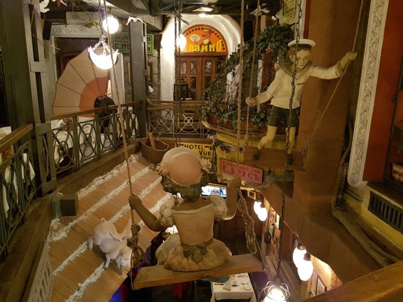 Interior of restaurant with old school statues on upper floor