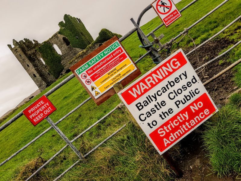 Ballycarbery Castle in the distance behind closed warning signs