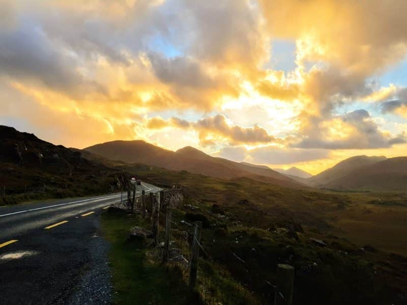 The sun setting behind a mountain along the Ring of Kerry scenic drive in Ireland