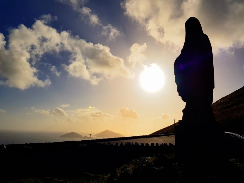 Virgin Mary statue in silhouette against the setting sun 
