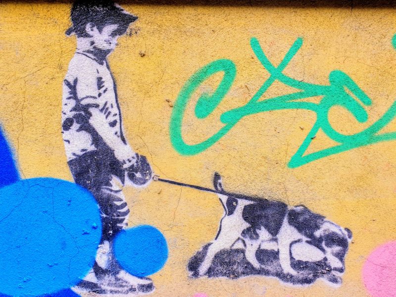 Street art of boy walking a dog