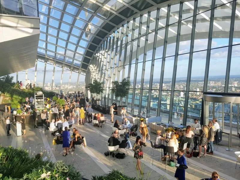 The interior of the Sky Garden filled with people enjoying the view