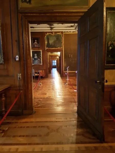Portrait photo of corridors highlighting the dark wooden floor and wooden doors.