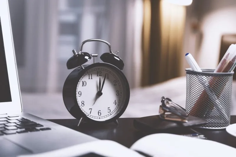 Clock on table. Just one of many ways to help you maximise saving for a holiday.