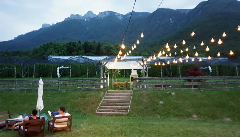 External view of Berry House Farm with overhanging lights and mountains in background