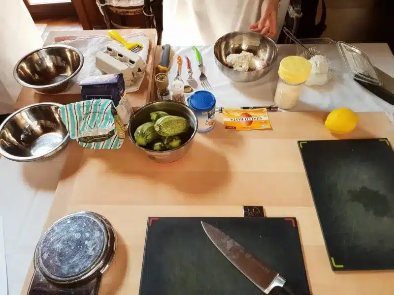 The kitchen table topped with the necessary utensils to cook up an Italian feast