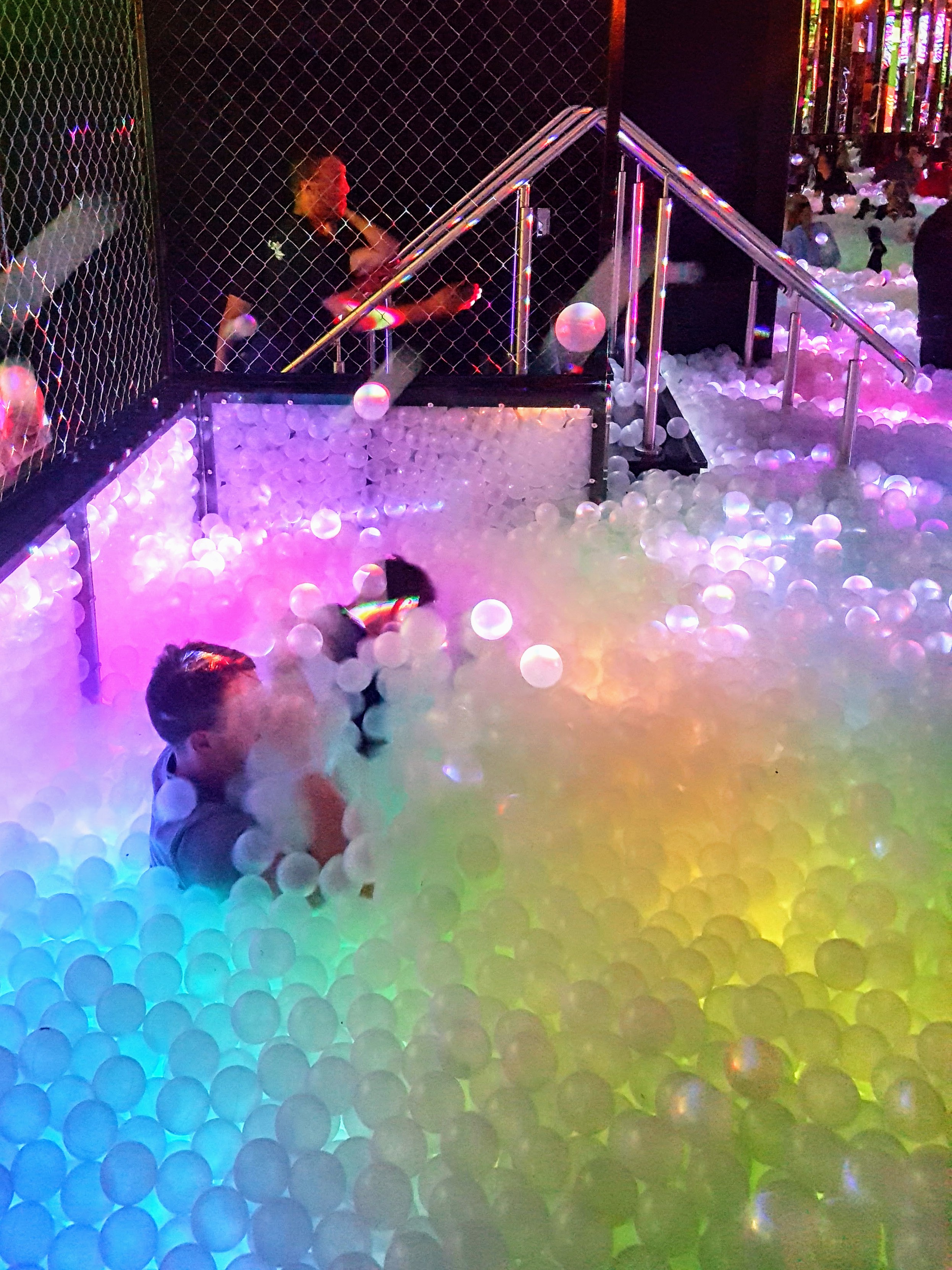 People in a ball pit at Ballie Ballerson Shoreditch throwing plastic balls at each other
