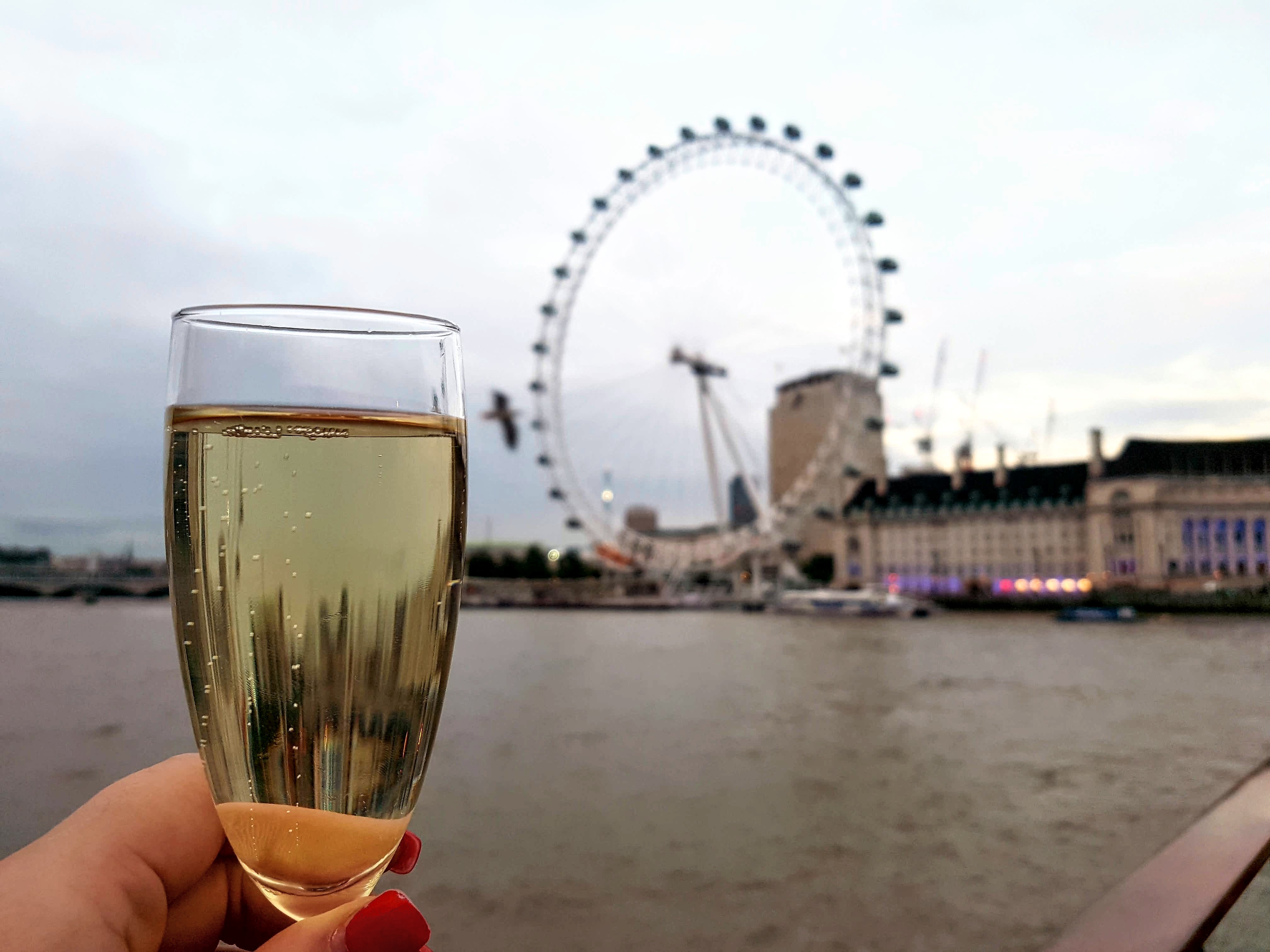 Champagne with London Eye in background whilst City Cruising