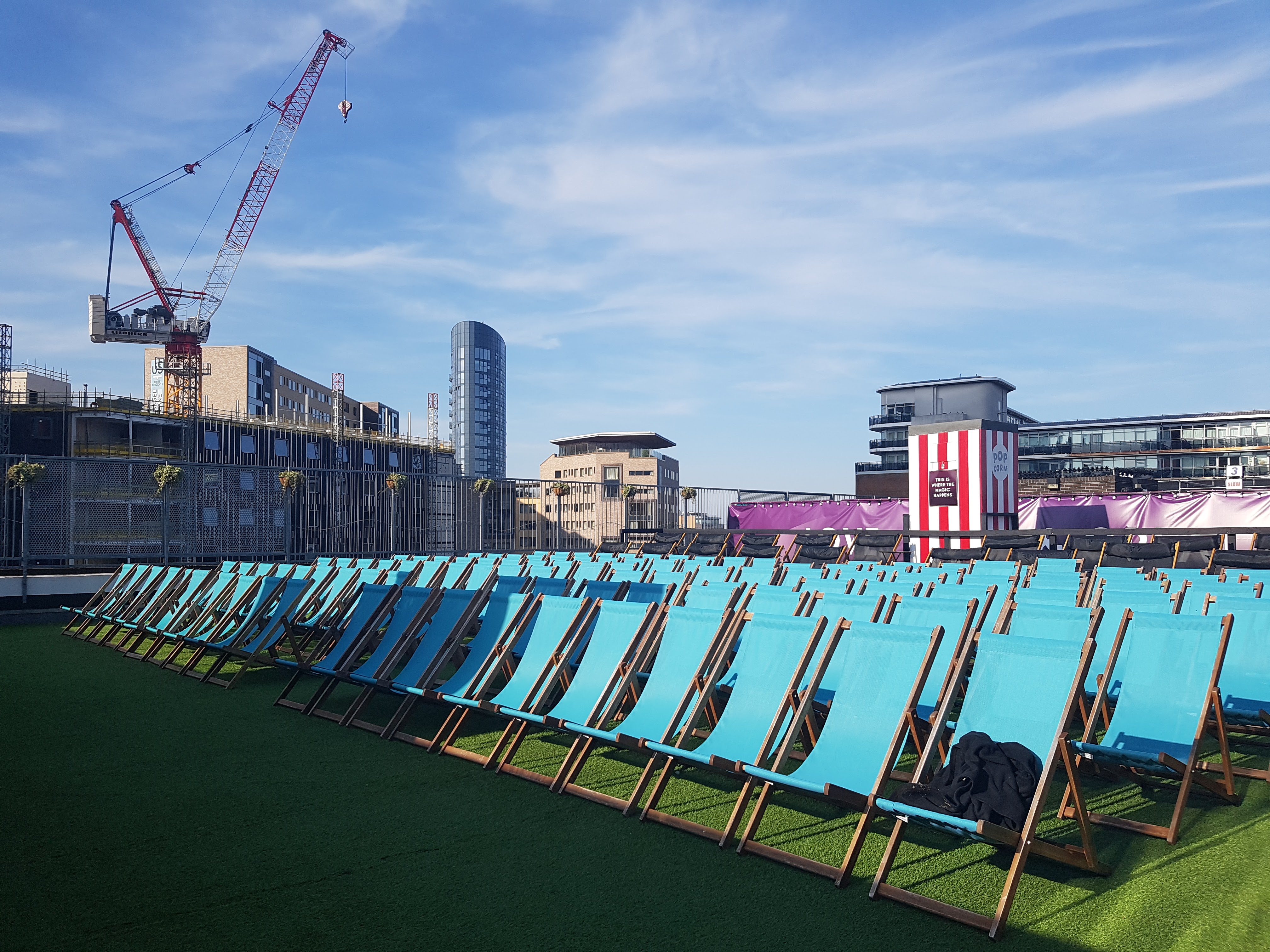 Rows of light blue deck chairs in Outdoor Cinema, Roof East