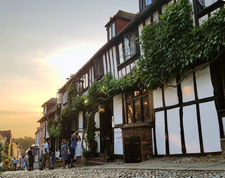 Cobblestone street in Rye, UK, with Mermaid Inn at sunset