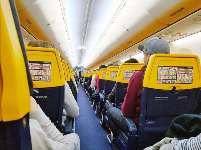 Onboard with Ryanair, the blinding daffodil interior of Ryanair and the safety card is stuck on in the seat in front. 