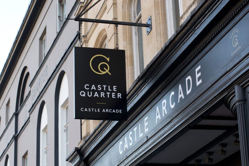 A sign for the Castle Quater hanging in front of the Castle Arcade shop front