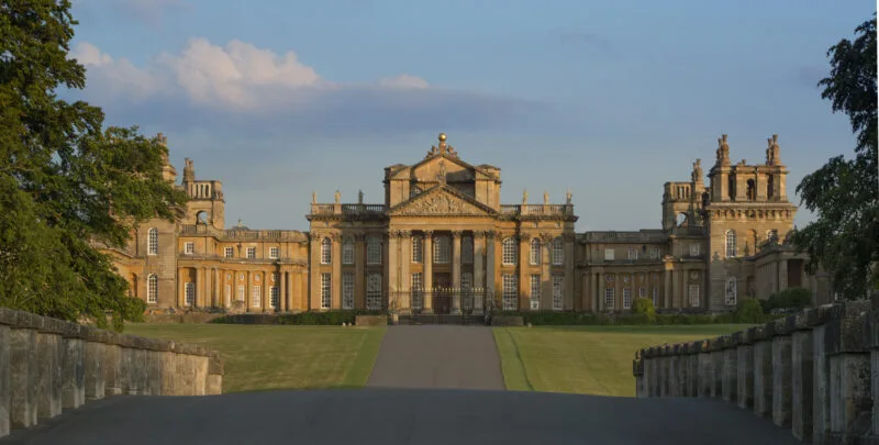 Exterior of Blenheim Palace with a leading road to the building. Just one of many places to include on this list of day trips from London by car