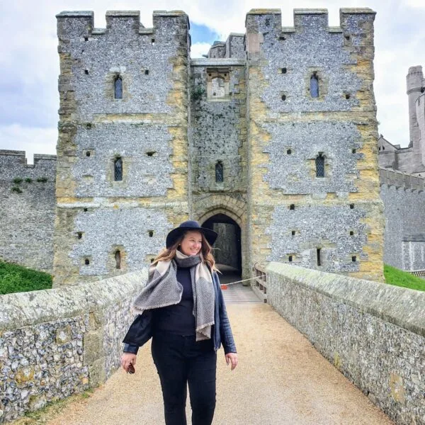 Roma standing in front of the entrance to Arundel Castle. Just one of many places for day trips from London. 