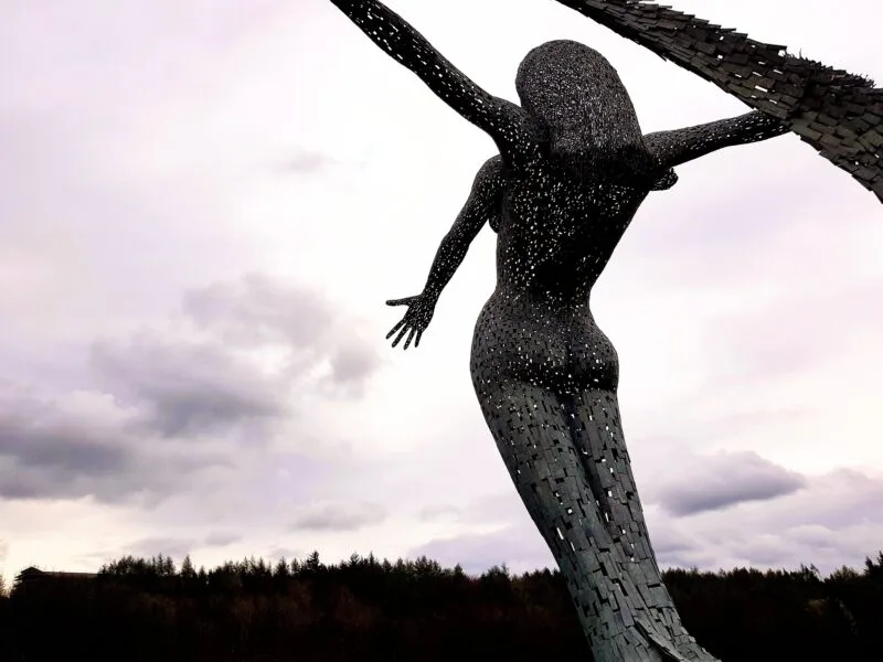 Arria sculpture shown from behind with light grey clouds in front