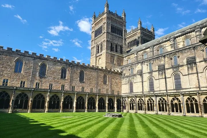 Exterior of Durham Cathedral captured from the cloisters. Lined green grass against Cathedral towers. Ideal for one of many things to do in Durham for couples