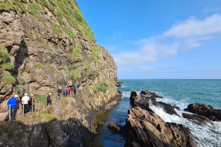 People walking along The Gobbins coastal path set along the basalt cliffs.