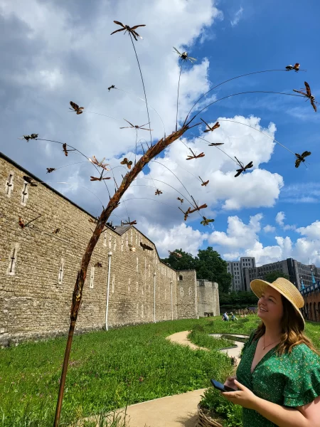 Roma looking at the insect swarm sculpture at Superbloom at the Tower of London