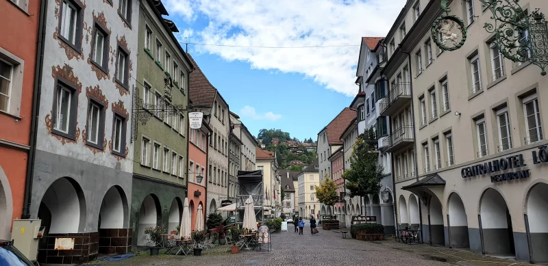 A wide-angled photo of the Marktgasse, buildings on either side with a pedestrians in the centre rear of the image. Just one of many things to do in Feldkirch Austria.