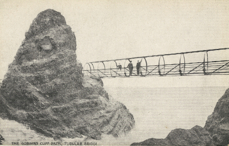An old photo of The Gobbins tubular bridge that shows people walking along the bridge