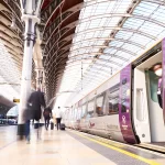 Heathrow Express train at Paddington Station with blurred passenger walking on platform