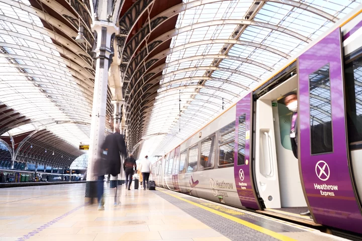 Heathrow Express train at Paddington Station with blurred passenger walking on platform