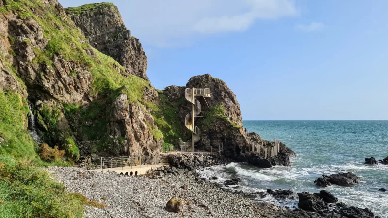 The view towards the entrance of The Gobbins cliff path walkway. A metal staircase in the distance.