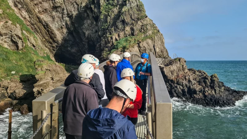 Tour group standing on bridge along The Gobbins cliff path in Northern Ireland