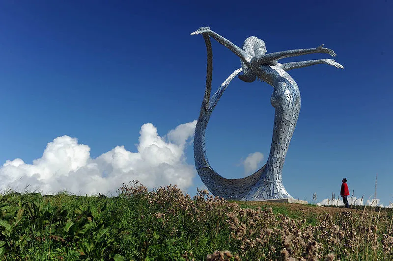 Arria sculpture with man standing at the base of the statue