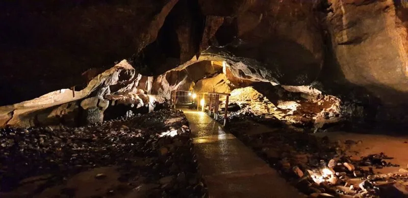 Dimly lit caves underground with a footpath through the middle