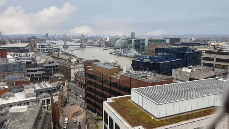 View from The Monument in London showing Tower Bridge in the distance and the rooftops of surrounding buildings.