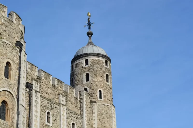 A view of the one of the towers of the Tower of London set against a clear blue sky