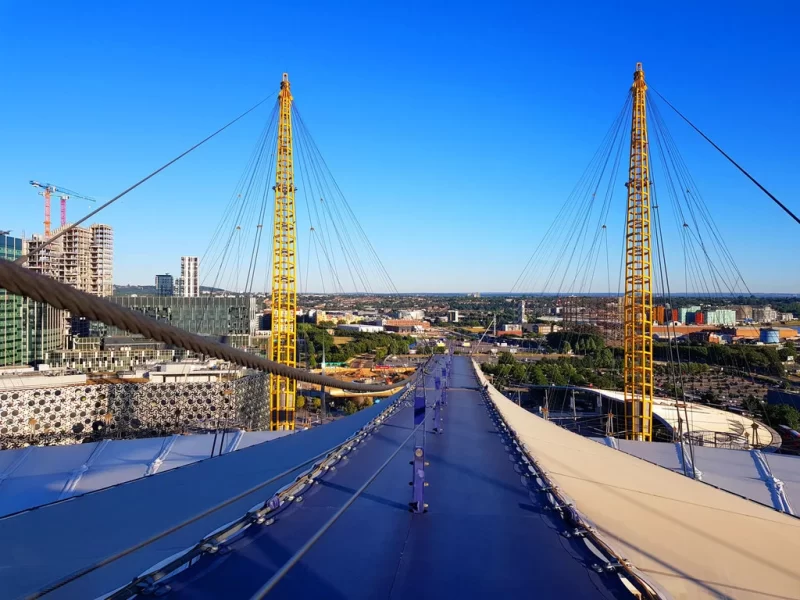 Image from atop of the O2 captured during the roof climb. Blue sky in the background and the yellow spires of the O2 are visible.