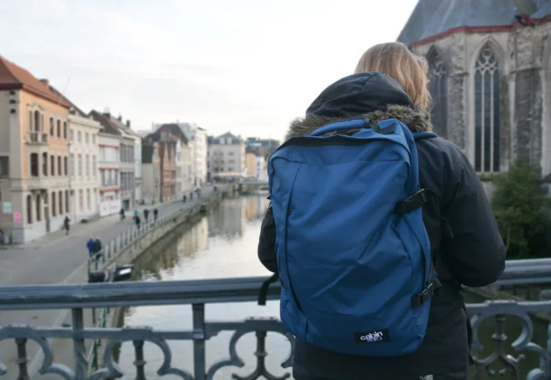 Roma wearing CabinZero backpack on a bridge during travelling