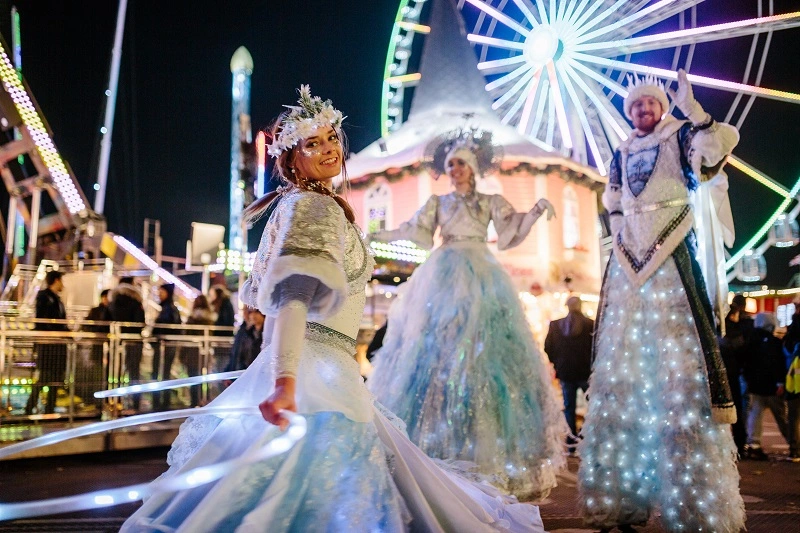 3 people dressed up in festive outfits for the Santa's Parade