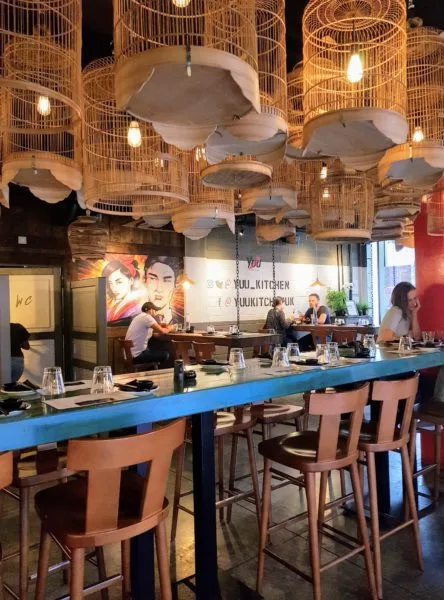 Timber bird cages hanging from the ceiling of the Yuu Kitchen restaurant in London