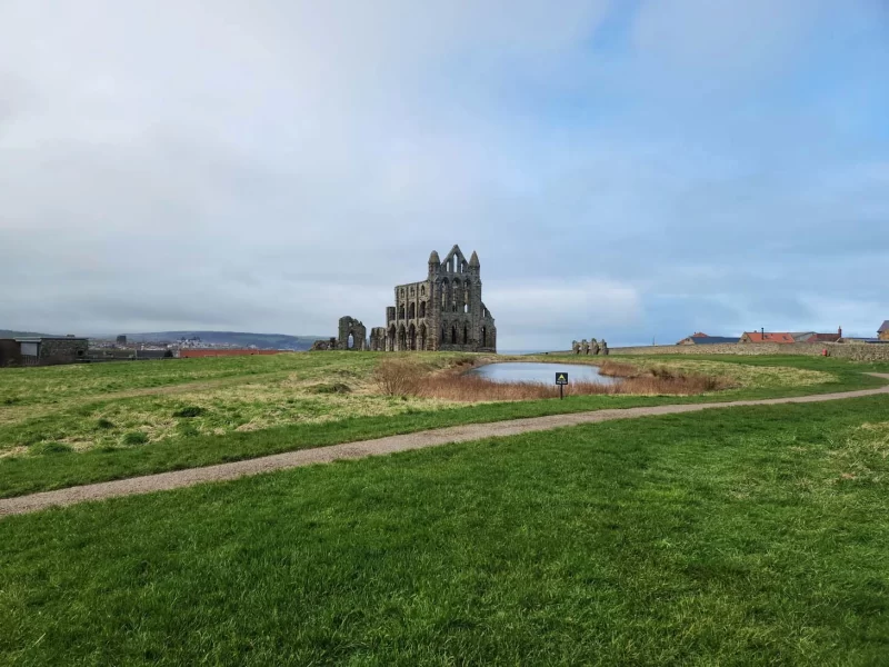 Whitby Abbey in the distance with walking path. 