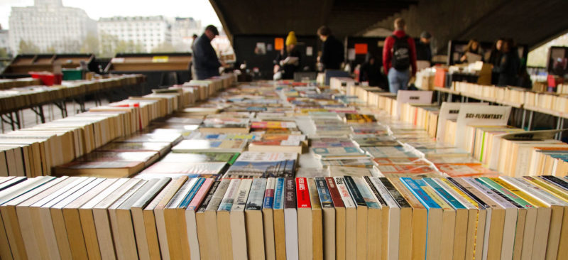 A large table of books for sale at London's Southbank Book Market 