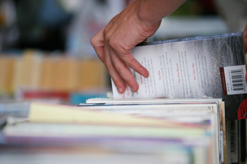 Close up of hand picking up a book
