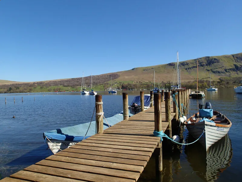 Boardwalk pier with small boats on either side