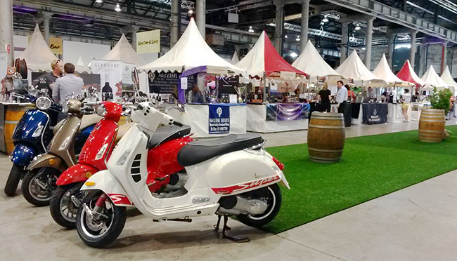 A series of vespas in front of stallholder tents