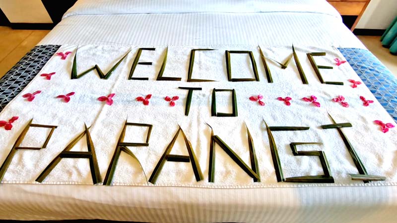 Bed decorated with "Welcome to Parangi" in palm leaves